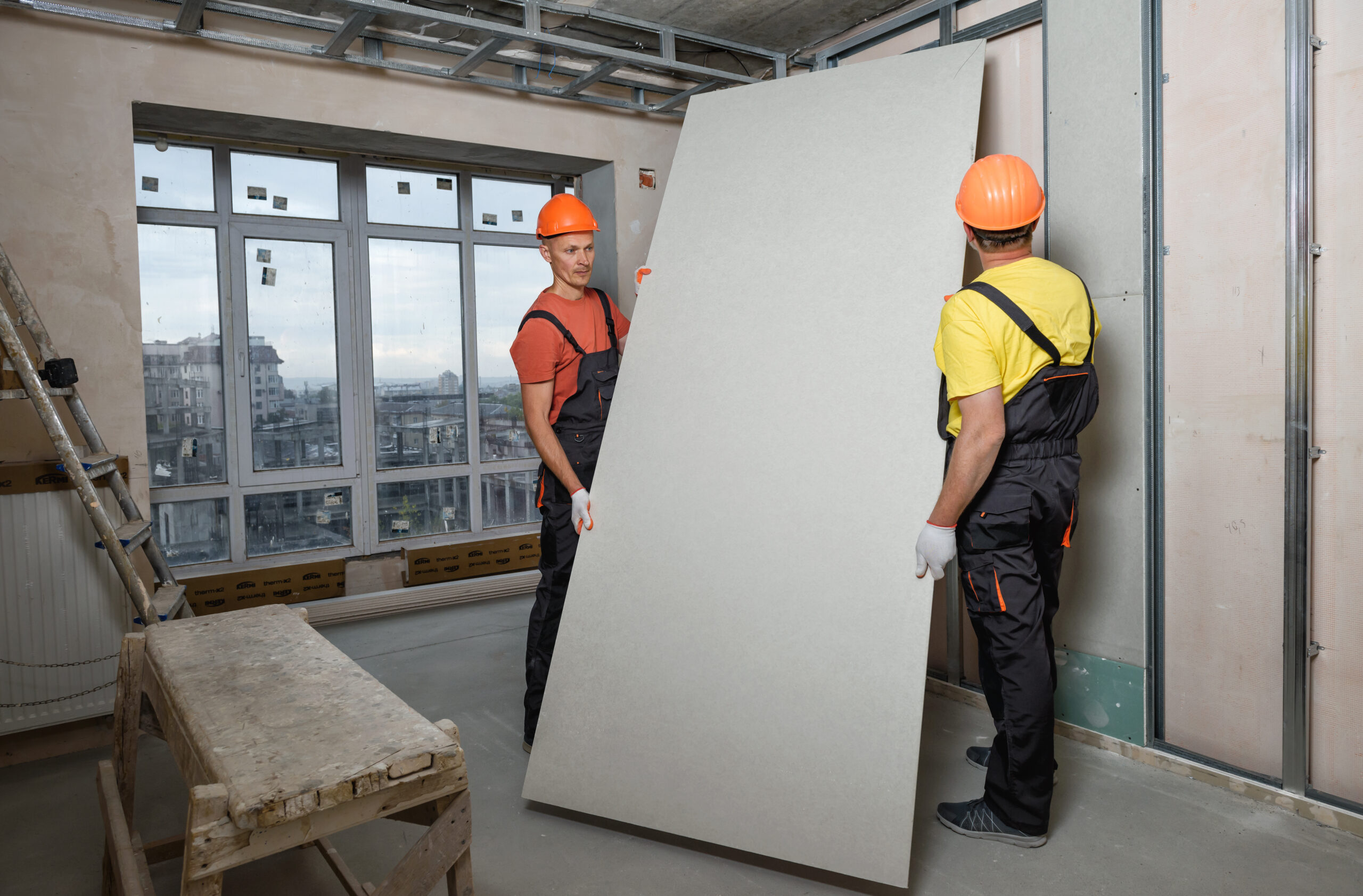 Drywall,Installation.,Workers,Are,Mounting,A,Plasterboard,To,The,Wall.